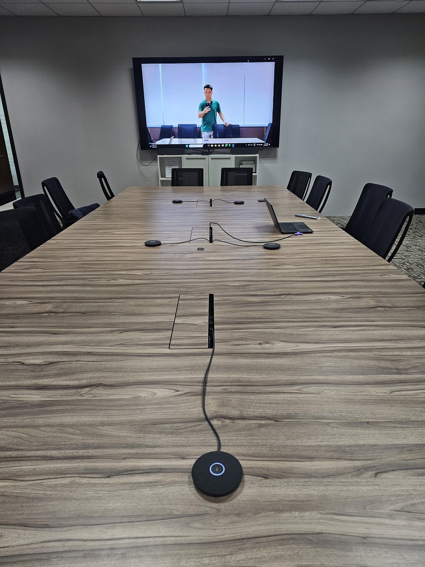 Professional boardroom video conferencing install by Unique Portal — multiple microphones and live call on display